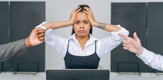 6 Types of Energy Vampires at Work and How to Handle Them Stressed woman at a laptop during a tense workplace interaction