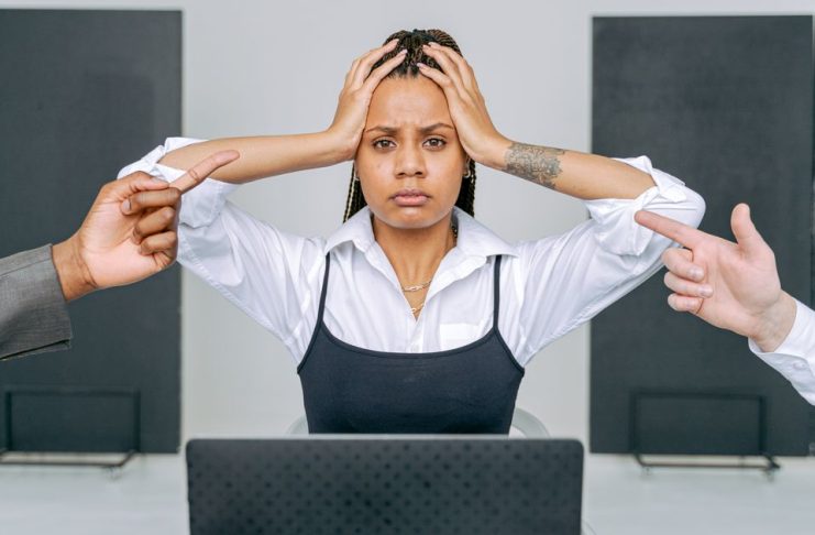 6 Types of Energy Vampires at Work and How to Handle Them Stressed woman at a laptop during a tense workplace interaction