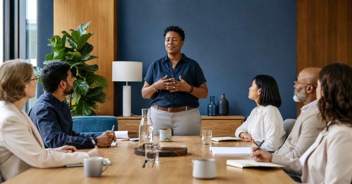 Workplace Mindfulness Guide Team lead offering an optional mindful pause in a modern workplace meeting