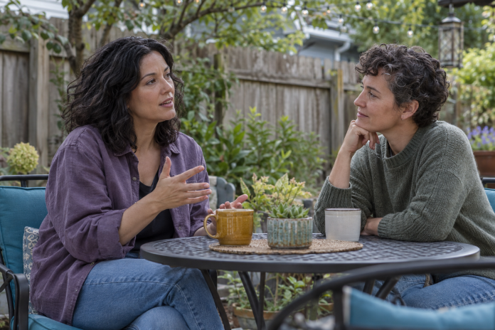 Supportive conversation in a home garden Two adults talking and listening at a table on a backyard patio.